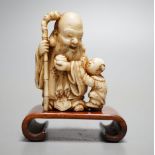 A Japanese ivory netsuke of Hotei and a boy, Meiji period, signed,5 cms high.