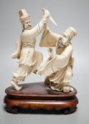 An early 20th century Chinese ivory group of two fighting officials - 21cm tall