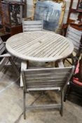 A circular weathered teak slatted garden table, diameter 122cm, height 74cm together with four