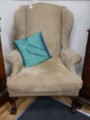 A heavy large upholstered wing armchair, width 92cm, depth 90cm, height 126cm