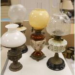 A Doulton style pottery oil lamp and four other glass and brass oil lamps, tallest 54 cms
