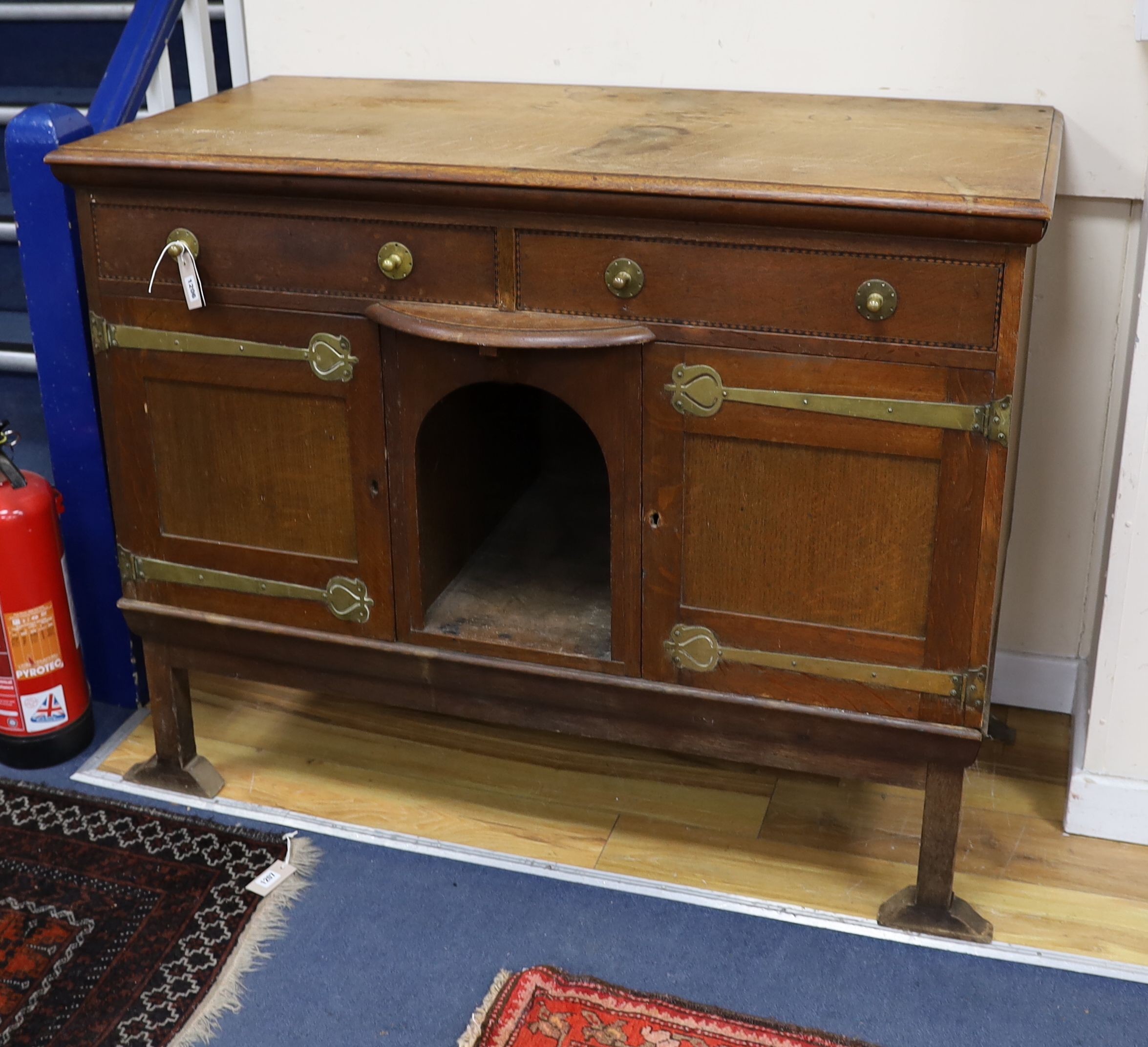 An Art Nouveau brass mounted oak buffet in the style of Voysey, length 124cm, depth 60cm, height