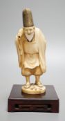 A Japanese ivory figure of a court official, wearing a tall eboshi hat, Taisho period, signed to a