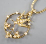 An Edwardian 15ct and seed pearl set openwork 'swallow and flower' pendant, 26mm, gross 2.5 grams,