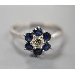 A modern 18ct white gold, single stone diamond and six stone sapphire set flower head cluster