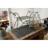 A wrought iron X framed stool, a pair of hanging planters and two large candle holders