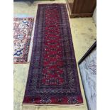 A Bokhara burgundy ground runner, 276 x 88cm