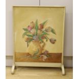 In the style of The Omega Workshop, a painted fire screen inset with a floral still life on board,