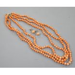 A triple strand coral bead necklace, 46cm and a pair of coral bead earrings.