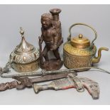 A group of Middle Eastern metalware, a kris, a jambiya, and a figurative carving, 31 cms high.