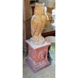 A reconstituted stone owl garden ornament on terracotta plinth, total height 130cm