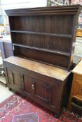 A 18th century and later small oak dresser with boarded rack, width 127cm depth 38cm height 166cm