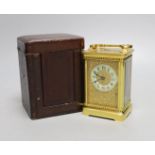 A cased French gilt brass carriage timepiece with relief cast dial and engraved presentation