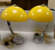 A pair of contemporary chrome reading lamps with yellow glass domed shades,46 cms high.