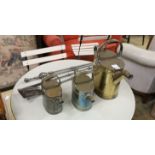 Three graduating brassed metal watering cans, largest height 40cm, together with a set of cast
