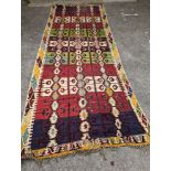 A Kelim polychrome flatweave carpet , cut centrally and re stitched, 425 x 163cm