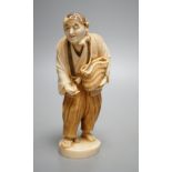 A Japanese ivory figure of a peasant farmer, Taisho/early Showa period, signed to a lacquer tablet -