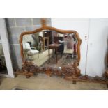 A near pair of Italian style carved walnut overmantel mirrors, decorated with winged figures,