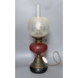 An Edwardian oil lamp with ruby glass font, later inverted to electricity,57 cms high including