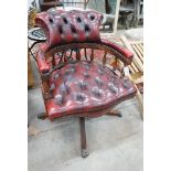 A reproduction Victorian style buttoned red leather upholstered swivel desk chair, width 63cm, depth