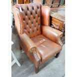 A modern buttoned brown leather wing armchair, width 70cm, depth 76cm, height 96cm