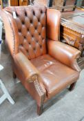 A modern buttoned brown leather wing armchair, width 70cm, depth 76cm, height 96cm