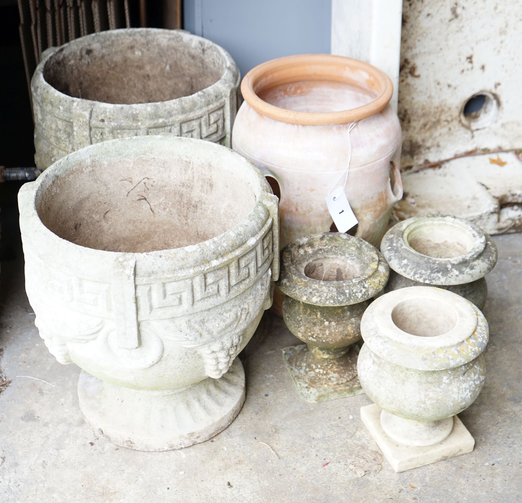 A pair of circular reconstituted stone garden urns, diameter 36cm, a terracotta strawberry pot and