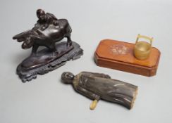 A Chinese horn figure and a carved hardwood figure riding a buffalo,13 cms wide.