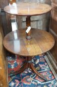 A George III circular mahogany two tier drop flap dumb waiter, height 97cm