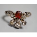 An early 20th century 18ct, garnet? and diamond cluster set dress ring(a.f.), with diamond set