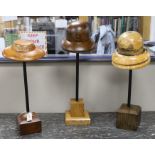 A group of three vintage milliner's hat-blocks, on stands