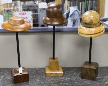 A group of three vintage milliner's hat-blocks, on stands