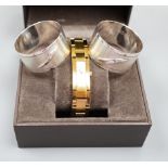 A modern pair of silver 'Concorde' napkin rings, together with a lady's gilded stainless steel Gucci