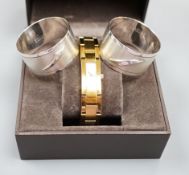 A modern pair of silver 'Concorde' napkin rings, together with a lady's gilded stainless steel Gucci