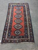 A Caucasian red ground rug, 210 x 110cm