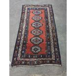 A Caucasian red ground rug, 210 x 110cm