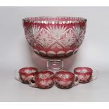 A Bohemian cut glass and cranberry overlay punch bowl with four glasses. Tallest 27cm