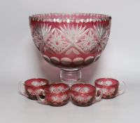 A Bohemian cut glass and cranberry overlay punch bowl with four glasses. Tallest 27cm