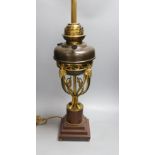 A gilt metal ‘rams head and hoof’ monopodia oil lamp, converted to electric, total height 72cm