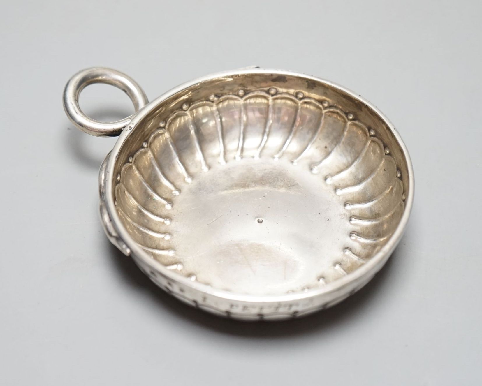 A late 18th/early 19th century French white metal taste vin, with engraved inscription and ring