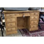 A Victorian style pine kneehole nine drawer desk with recessed cupboard, length 130cm, depth 50cm,