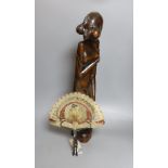 A Burmese carved hardwood figure, 51.5cm tall, and a Burmese horn and animal-bladder fan