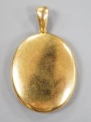 A late Victorian yellow metal oval mourning locket, containing plaited hair, overall 50mm, gross