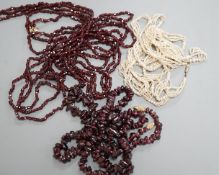 An early 20th century triple strand facet cut garnet necklace, with yellow metal clasp, 122cm, a