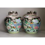 A pair of Japanese famille noire jars and covers 27cm