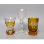 Two Bohemian wheel engraved amber flashed beakers, one with titled topographical views and a wheel