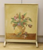 In the style of The Omega Workshop, a painted fire screen inset with a floral still life on board,