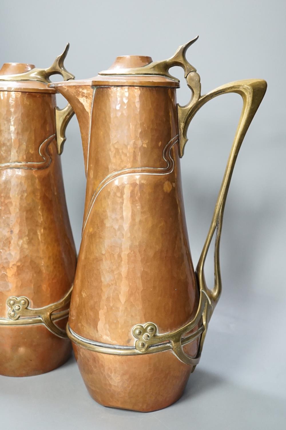 A pair of German or Austrian Jugendstil copper and brass jugs, 38cm - Image 2 of 6
