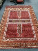 An Afghan red ground rug, 248 x 174cm