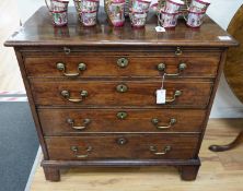 A George III mahogany chest of four graduating long drawers with brushing slide and brass handles,